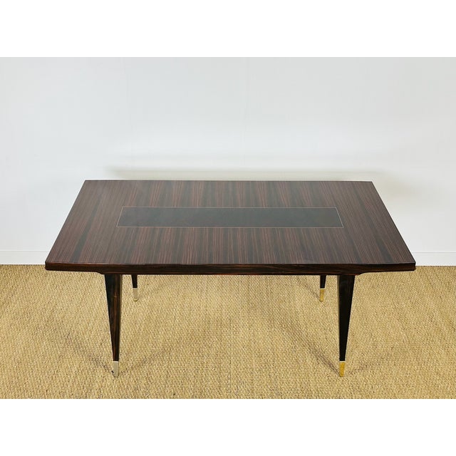 A sublime art deco extendable table crafted from varnished macassar ebony, featuring a magnificent vertical grain veneer...