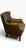 We are pleased to present this wonderfully aged brown leather armchair. There are no cracks or rips on this chair, just...