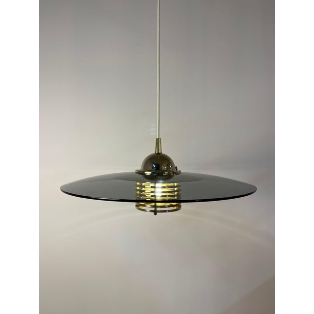 This pendant lamp, crafted from smoked glass and brass by jan eskil eskilsson for the renowned swedish manufacturer belid,...