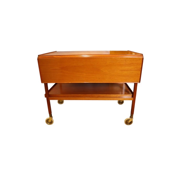 With slender legs on casters, a double ended drawer accessible from both sides of the cart, and two fold out leaves, this...