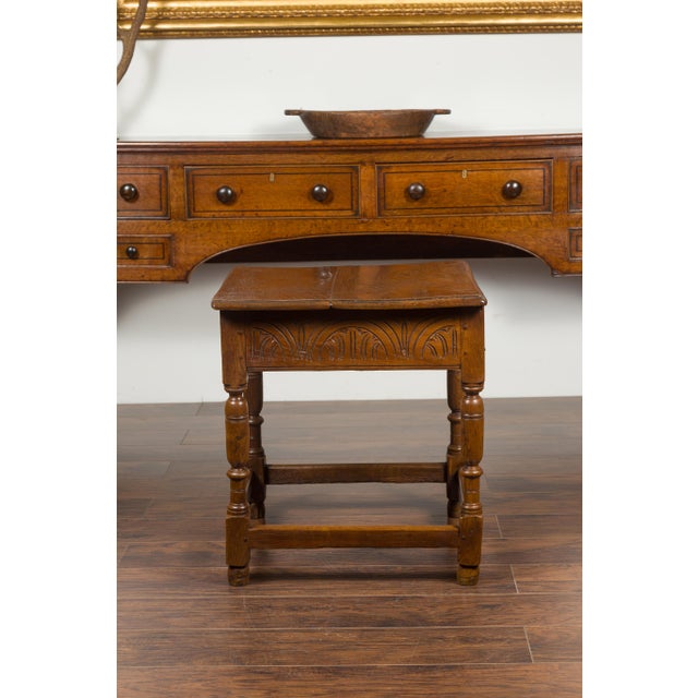 An English Georgian period oak table from the early 19th century, with lift top and turned base. Born in England during...