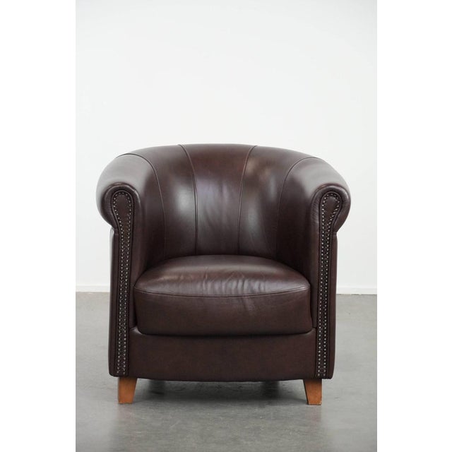 This English-style cowhide armchair has a beautiful, uncommon brown/dark purple color scheme. The armchair is finished...