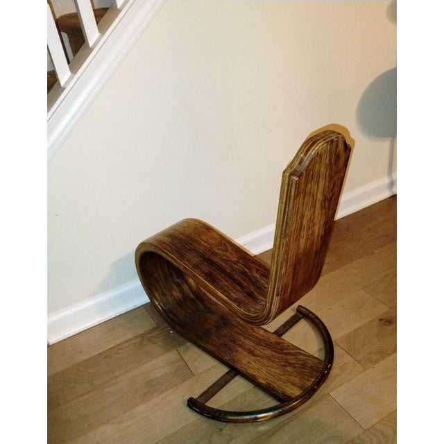 This stunning piece features a single, continuous curve of rich, warm-toned wood, offering a sculptural statement for any...