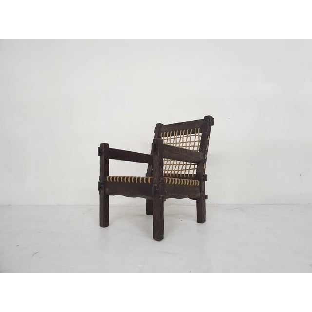 Beautifuly carved wooden lounge chair with rope seating and back.