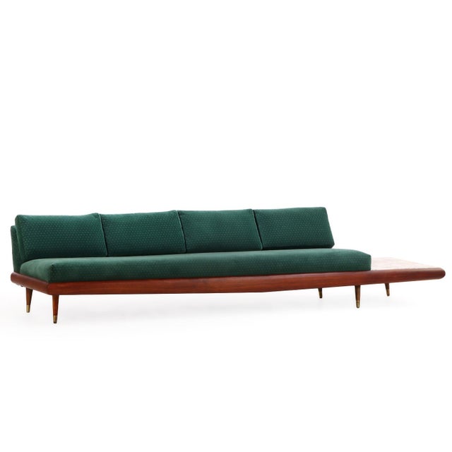 Featuring a sculptural walnut frame with a finished back, teal upholstered seat cushions in velour, and integrated marble...