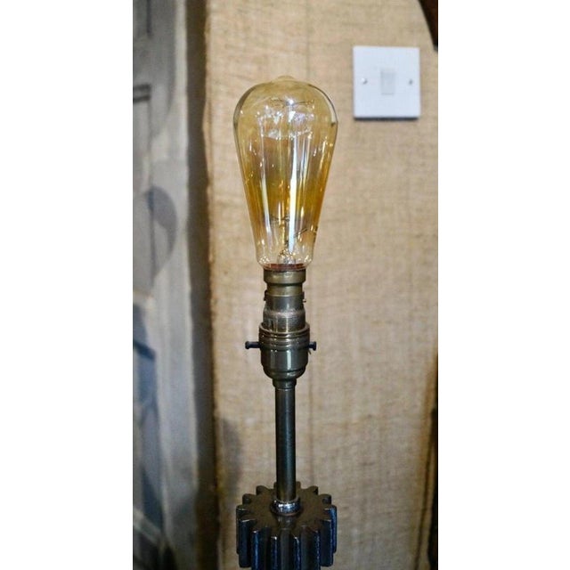 A distinctive antique industrial table lamp fashioned around a traditional candy roller mechanism, combining the character...