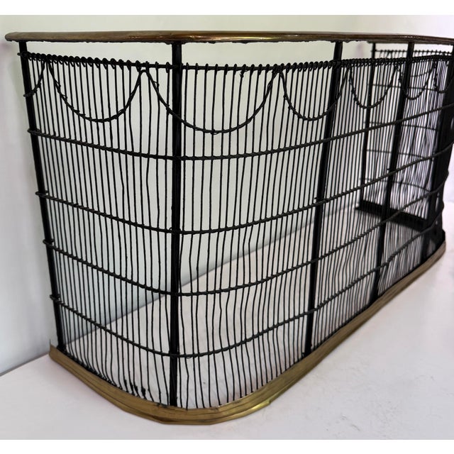 A beautifully handcrafted vintage fireplace fender featuring a graceful bowed front with hand-forged wrought iron...