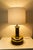 Late 20th-century mercury glass table lamp featuring a reflective gold-tone finish and a sculptural silhouette, all set on...