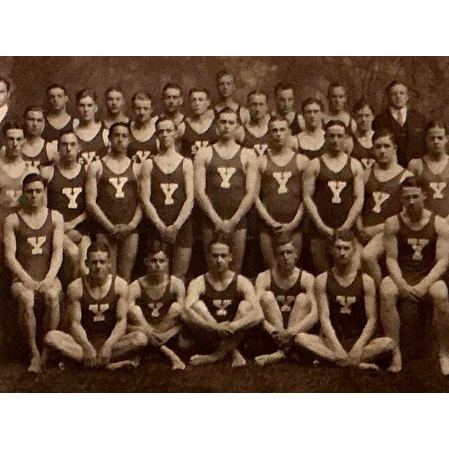 Immerse your space in the nostalgic charm of classic Americana with this vintage sepia-toned photograph of the Yale...