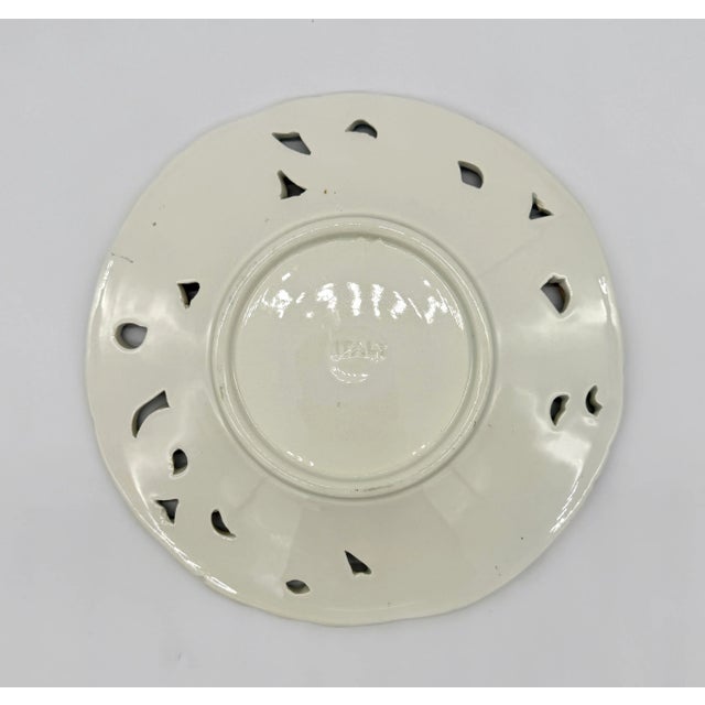 This beautiful 8" reticulated plate is one of three in our collection, each with a unique floral majolica painting with...