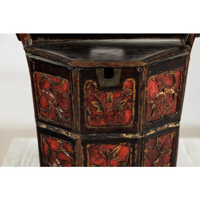 A late Qing dynasty Chinese wooden rice measure, hand-carved and richly lacquered in red and black, with traces of gilt...