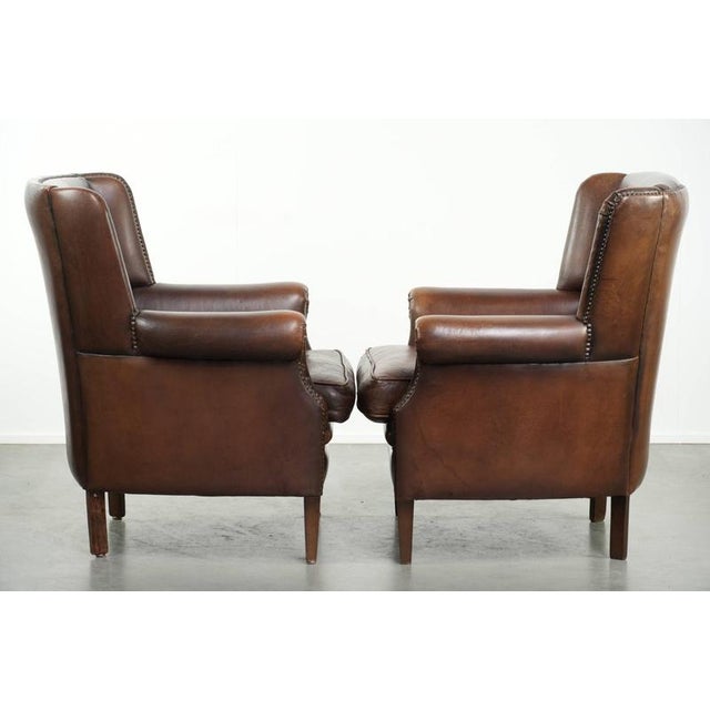 This lovely set of 2 subtle English-style sheepskin wingback armchairs features beautiful colors and is equipped with a...