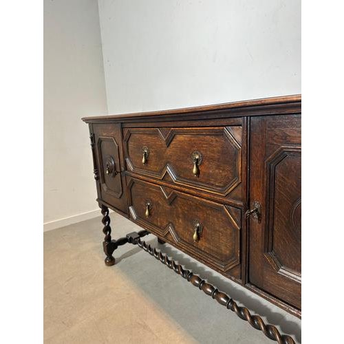 Beautiful antique oak sideboard with a warm dark patina and stunning carved panel details. This piece features two doors...