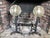 A pair of large antique English brass and iron fireplace andirons with decorative circular medallion tops with ornate...