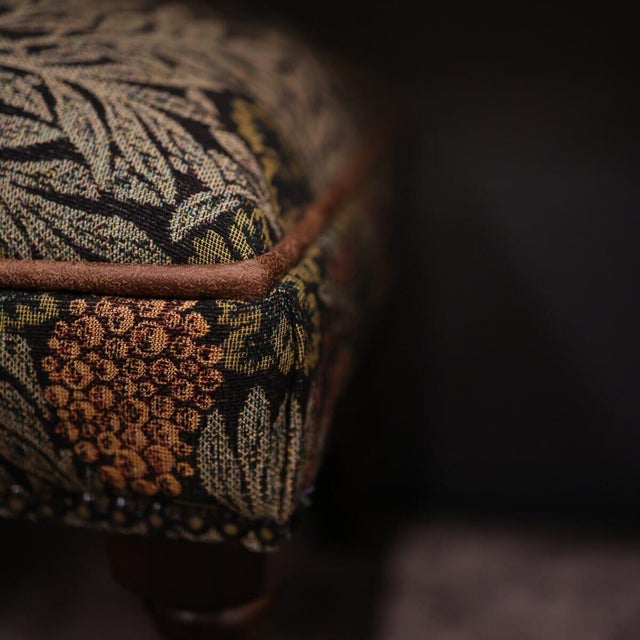 Meticulously handcrafted in the United Kingdom, this upholstered stool boasts classic studding and hand-polished solid...