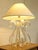 A glamorous sculptural table lamp featuring a clear lucite base formed from sweeping loops and curved lucite ribbons...