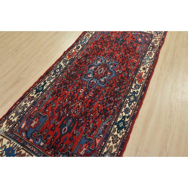 An authentic vintage tribal Hamedan runner hand-knotted with fine wool and natural dyes. This rug features a central...