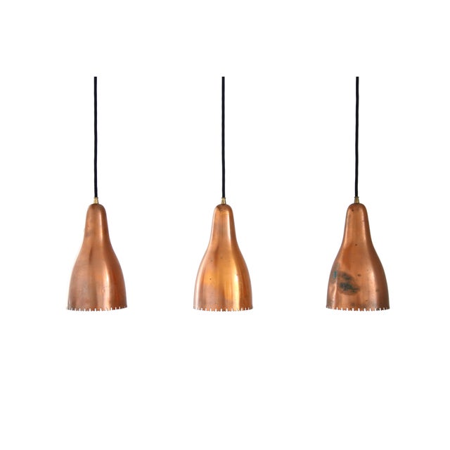 Set of three perforated copper pendant lamps designed by Bent Karlby, from the 1950s, manufactured for Lyfa. Elegantly...