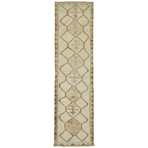 This exquisite runner rug is a rare example of tribal craftsmanship, hand-knotted by the women of the Herki tribe during...