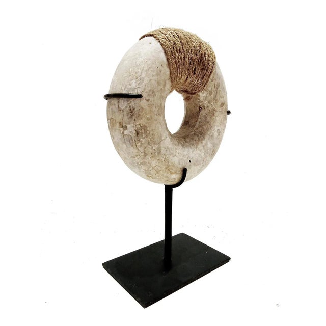 A decorative stone bracelet, with raffia rope addition. Mounted on a made-to-measure black metal stand. 6 inches in...