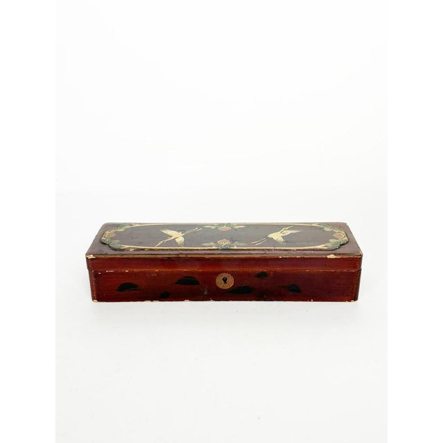 An elegant rectangular lacquered wood box, featuring a delicate hand-painted design on the lid depicting two cranes in...