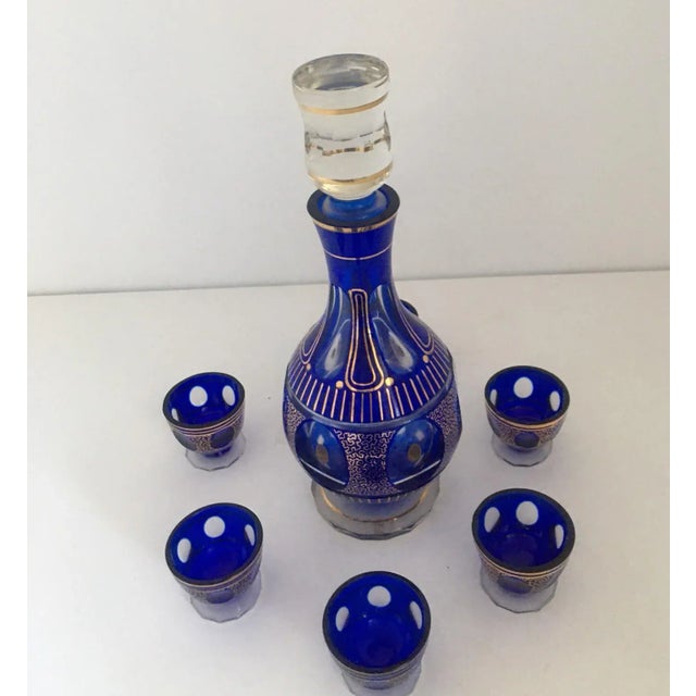 Bohemian cut crystal liqueur set decorated with dark purple glass and hand-painted in gold. The set includes six pieces of...