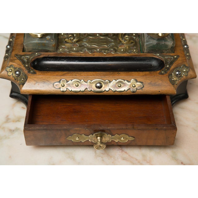 English Victorian inkwell set. This walnut set has been accented with an ebony color and an overall brass decoration, mid-...