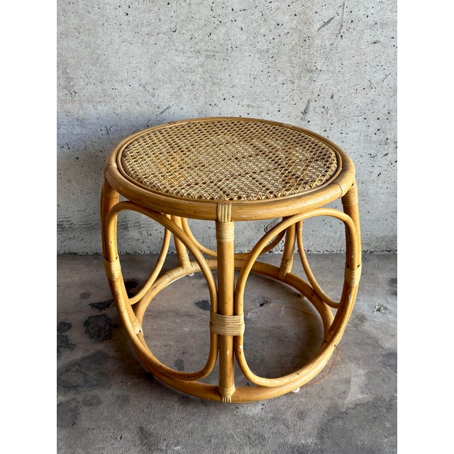 A relaxed yet sculptural vintage bamboo and cane side table, embodying the effortless Riviera aesthetic of the...