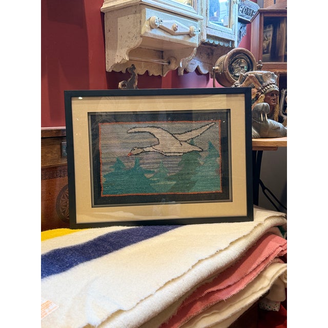 A wonderful example of early Canadian folk art, this vintage Grenfell Industries hooked mat depicts a majestic snow goose...