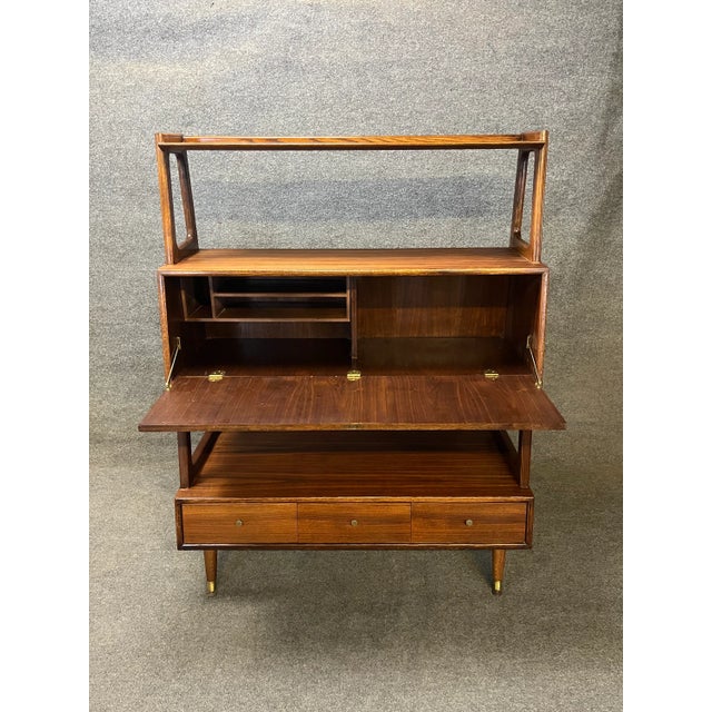 Here is an exceptional Mid-Century Modern bookcase wall unit, room divider, or etagere with slant front secretary desk. By...