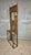 A striking vintage hall tree made of carved oak, featuring an integrated central mirror, multiple coat hooks, decorative...