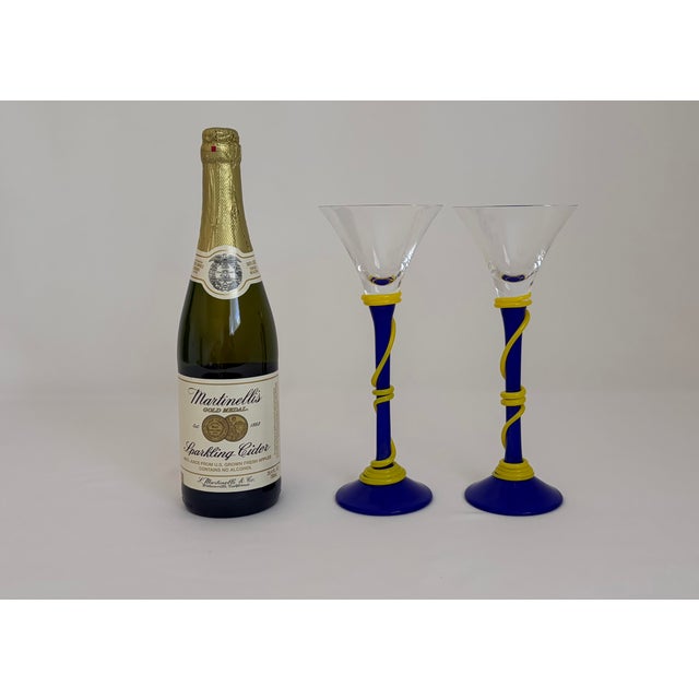 Striking pair of signed art glass martini/cocktail glasses designed by Shafaq Malik. Each glass features a clear flared...