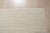 A handwoven wool flatweave, made in India and measuring 6' x 9'. An open, largely solid field with restrained detail at...