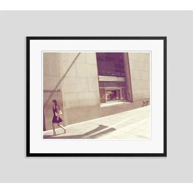 Tiffanys' by stuart möller a young woman passes by the infamous diamond & jewellery store, tiffany’s in new york, with...