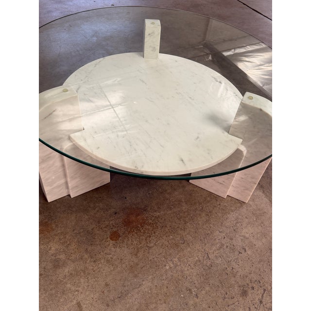 The Nico Coffee Table features a stunning white/grey marble base with a shelf, topped with a glass surface. Part of...