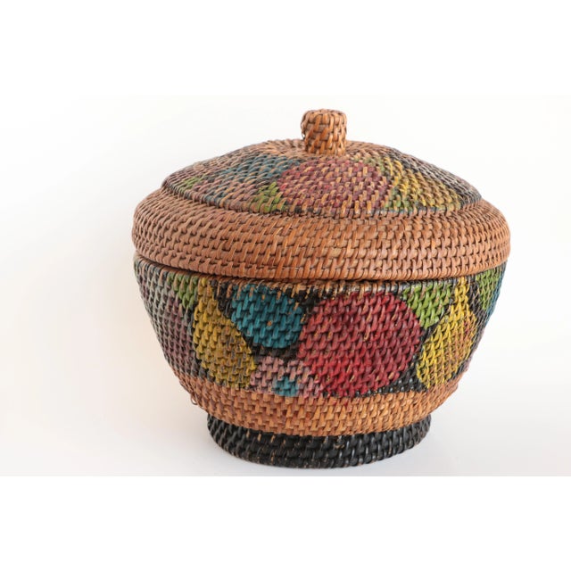 Lidded rattan basket with colorful wraparound abstract painted fruit decoration. The lid's painted finish is considerably...