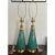 A pair of vintage mid-century modern ceramic table lamps featuring a distinctive turquoise or teal glaze with gold...