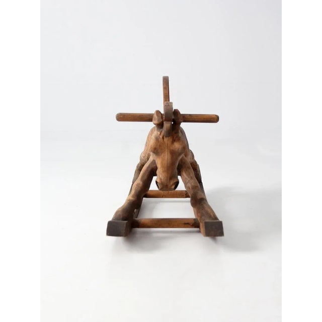 A rare find! This wood folk art rocking horse was meticulously hand carved with a single block of wood, and is mounted...