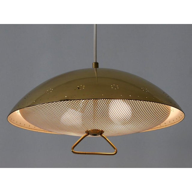 Rare, elegant and highly decorative mid-century modern perforated metal pendant lamp or hanging light. Designed &...