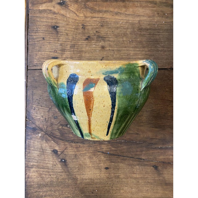 Antique French terracotta jardinière with four loop handles and a striking green, yellow and ochre drip glaze. Made as a...