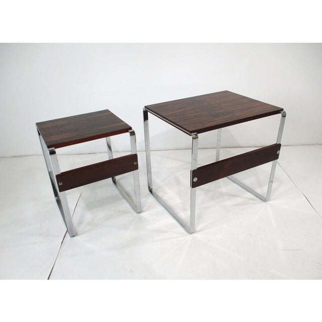 A set of two chromed framed side tables with very well grained Brazilian rosewood tops and stretchers. Manufactured in the...