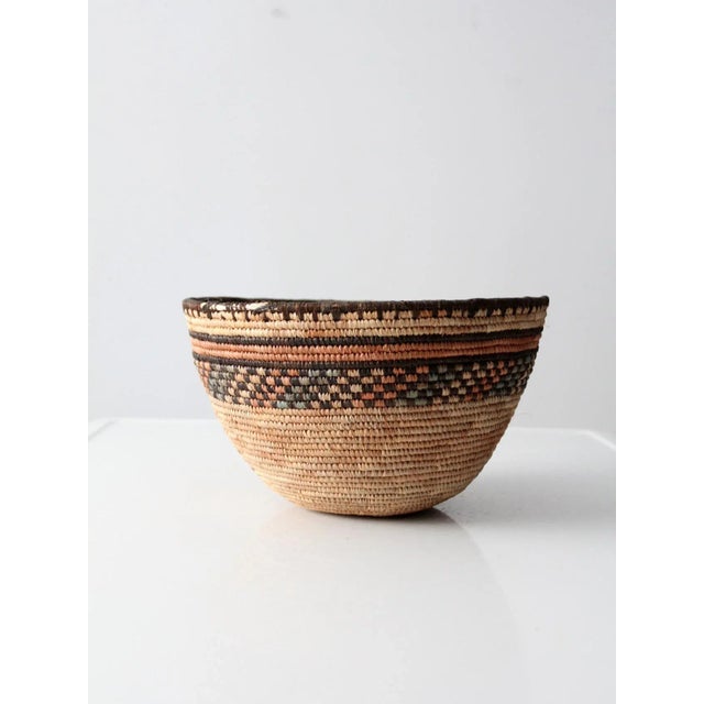 This is a beautifully hand-woven vintage basket. The bowl features a decorative stripe and checked pattern across the top...