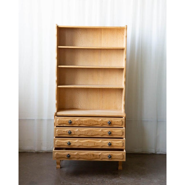 A tall Danish oak bookcase produced in the 1970s in the manner of Henning Kjærnulf, combining the clean proportions and...