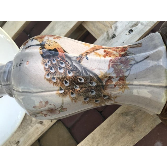 Signed ceramic Japanese table lamp with a Peacock motif on a teak base. Very good condition. Lampshade new. The E27 bulb...