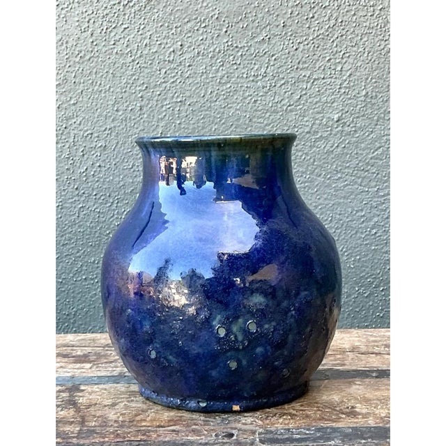This vintage cobalt studio pottery vase showcases a classically balanced silhouette, its rounded, bulbous body rising...