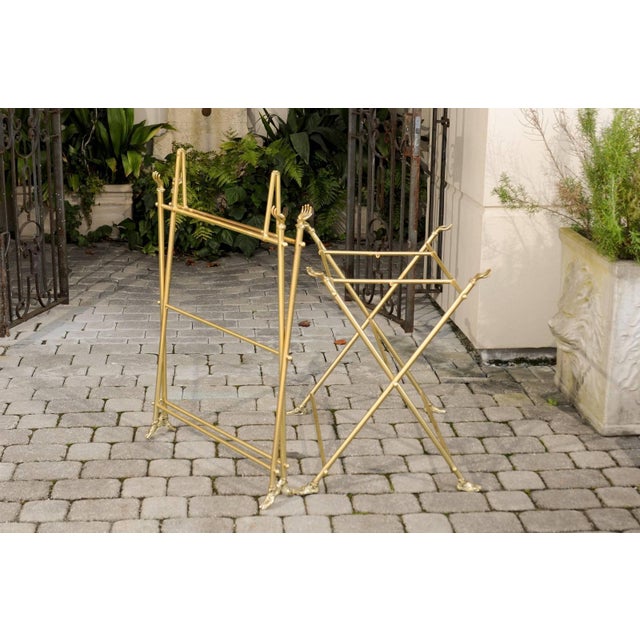 A pair of 1960s Italian brass and glass folding side tables with cast brass hands and sandaled feet. Each of this pair of...