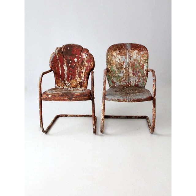 This is a pair of mid-century metal patio chairs. One chair features the classic "shell" back, and the other has a more...