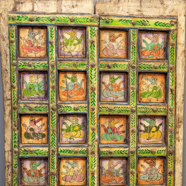Pair of carved and painted antique teak haveli doors as wall art from Rajasthan with original hardware. On the front of...