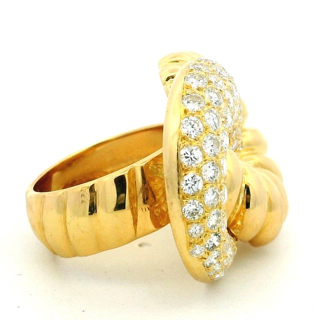 A bold 1970s Italian cocktail ring crafted in solid 18K yellow gold, featuring a sculptural swirl design accented with...