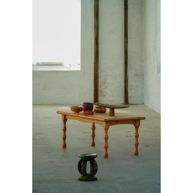 A charming Danish brutalist coffee table crafted from solid pine during the 1970s. The table showcases the warm golden...